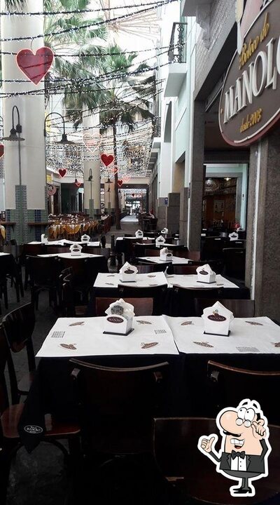 Sente em uma das mesas no Boteco do Manolo Nova America