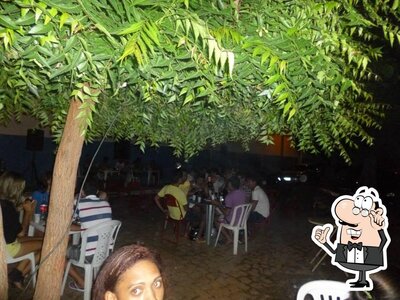 Sente em uma das mesas no Buga’s bar & restaurante