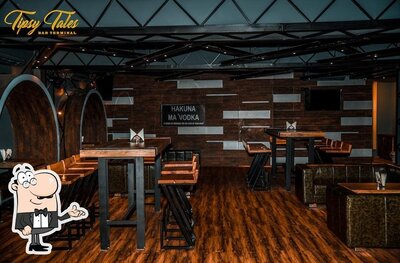 Take a seat at one of the tables at Tipsy Tales Bar Terminal
