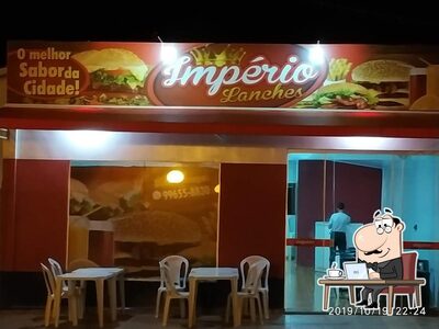 Sente em uma das mesas no Império lanches