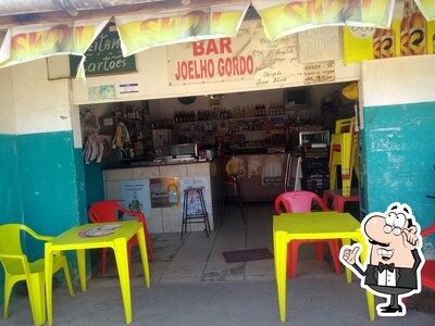 Sente em uma das mesas no Bar Joelho Gordo