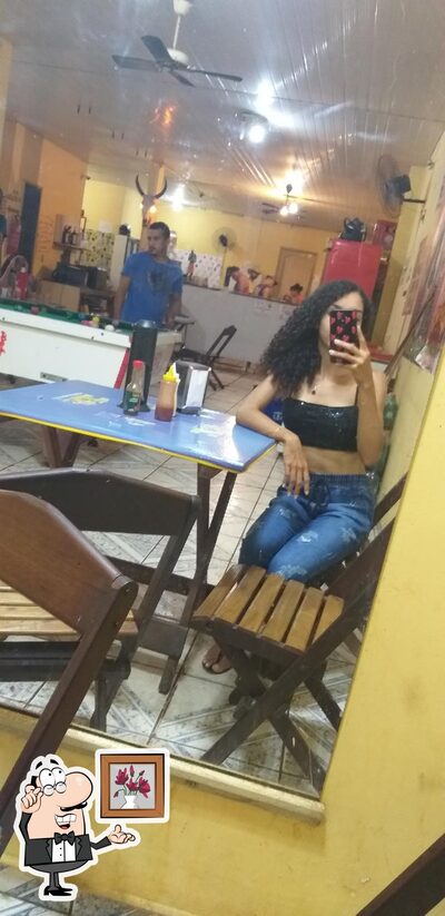 Sente em uma das mesas no bar dos cornos
