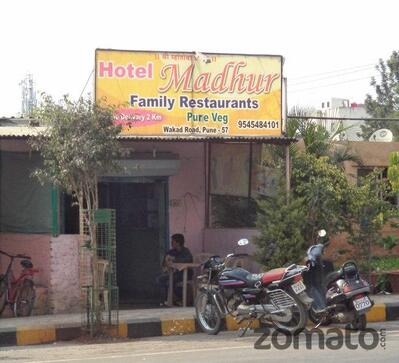 The advertisement displays information about Madhur Family Restaurant